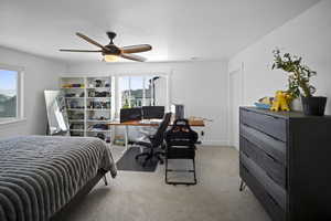 Carpeted bedroom featuring a ceiling fan