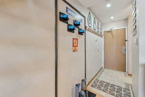 Doorway with light tile patterned floors and recessed lighting