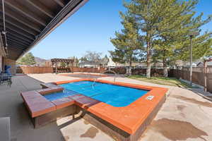 View of swimming pool featuring a fenced backyard, a pool, and a patio