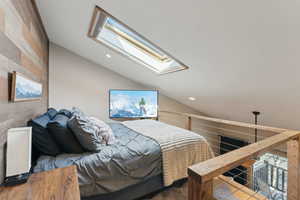 Bedroom featuring vaulted ceiling with skylight and recessed lighting