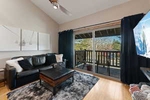 Living area featuring light wood-type flooring, a ceiling fan, and high vaulted ceiling