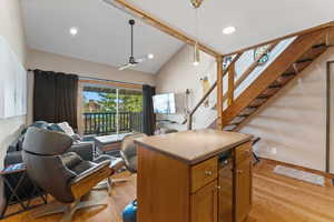 Kitchen featuring open floor plan, a center island, ceiling fan, and hanging light fixtures