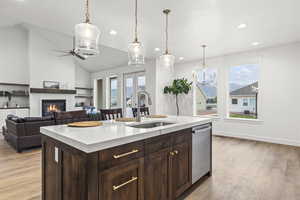 Kitchen featuring a sink, light countertops, dishwasher, light wood-style flooring, and recessed lighting