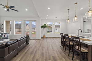 Living area with baseboards, a ceiling fan, wood finished floors, and recessed lighting
