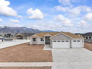 Ranch-style home with fence, concrete driveway, a mountain view, and a garage