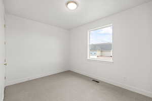 Spare room with light colored carpet, baseboards, and visible vents