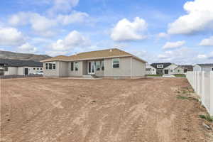 Back of property featuring fence, a residential view, and stucco siding