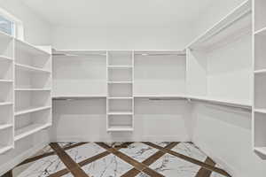 Walk in closet with marble finish floor