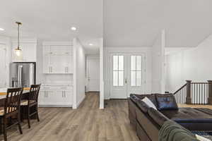 Living area with light wood finished floors and recessed lighting
