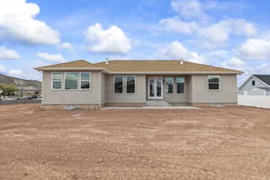 Back of house featuring stucco siding, fence, a patio, and french doors