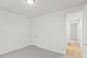 Spare room featuring light carpet and baseboards