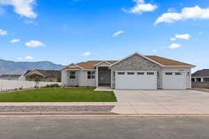 Ranch-style home with board and batten siding, a garage, concrete driveway, a mountain view, and roof with shingles