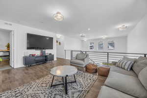 2nd level family room area with a healthy amount of sunlight and wood finished floors