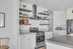Kitchen featuring custom cabines; open shelves; exhaust hood; & finish carpentry.
