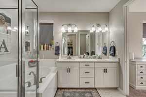 Full bathroom featuring a bath, marble finish floor, a sink, and double vanity