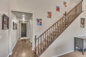 Stairs with baseboards and wood finished floors