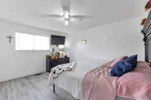Bedroom with a ceiling fan, baseboards, visible vents, and light wood finished floors