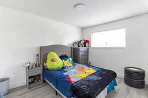Bedroom featuring wood finished floors and baseboards