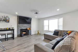 Living area featuring recessed lighting, wood finished floors, and a fireplace