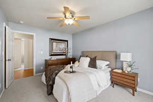 Bedroom with a ceiling fan, baseboards, and carpet floors