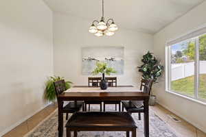 Dining area with visible vents, an inviting chandelier, a healthy amount of sunlight, and light tile patterned floors