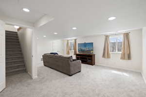 Living area with baseboards, carpet, recessed lighting, and stairway