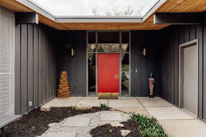 Doorway to property featuring board and batten siding and covered porch