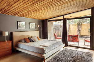 Bedroom featuring vaulted ceiling, access to exterior, wooden ceiling, and visible vents