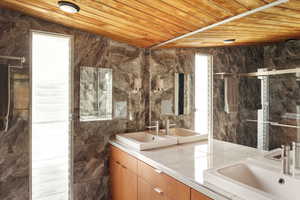 Full bath featuring wood ceiling, a sink, and a stall shower