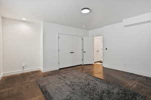Unfurnished bedroom featuring baseboards and a textured ceiling