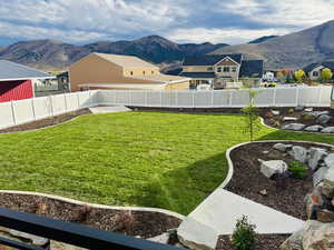 Fenced backyard featuring completed landscaping and mountain view.
