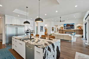 Kitchen with stainless steel appliances, modern cabinets, a sink, a kitchen island with sink, and white cabinetry