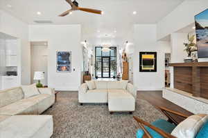 Living room featuring a ceiling fan, baseboards, recessed lighting, and dark wood finished floors