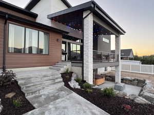 View of side of property featuring a patio area and a hot tub