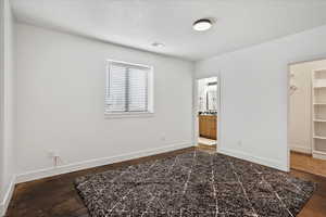 Unfurnished bedroom featuring a closet, a spacious closet, connected bathroom, baseboards, and visible vents