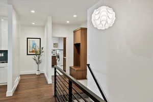 Corridor with recessed lighting, an upstairs landing, dark wood-type flooring, independent washer and dryer, and baseboards