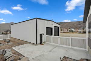 View of outbuilding with fence and a mountain view
