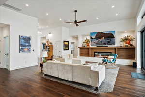 Living room featuring a glass covered fireplace, wood finished floors, recessed lighting, and ceiling fan