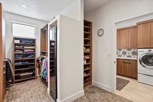Laundry room with washer / dryer, baseboards, a textured ceiling, and cabinet space