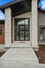 Property entrance with a porch and stone siding