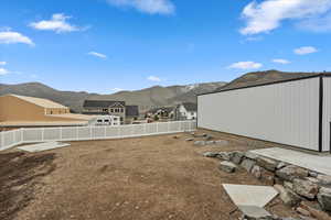 View of yard featuring a fenced backyard, a mountain view, and a residential view