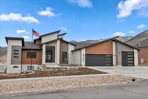 Contempary home with concrete driveway, a mountain view, and a garage