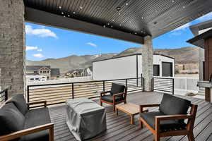 Wooden deck with a mountain view, an outdoor living space, and a residential view