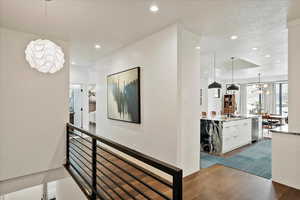 Hall with a sink, an inviting chandelier, recessed lighting, and dark wood finished floors