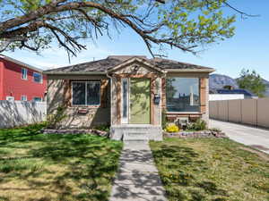 Bungalow-style house with fence, a front lawn, and a mountain view