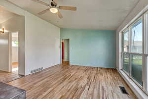 Spare room with vaulted ceiling, visible vents, and a wealth of natural light