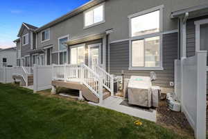Rear view of house featuring central AC unit and a yard