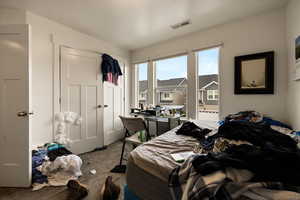 Bedroom with visible vents, carpet floors, and a closet