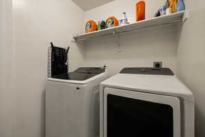 Washroom featuring washing machine and dryer and laundry area