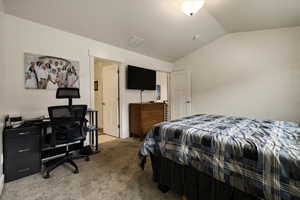 Bedroom featuring lofted ceiling and carpet flooring
